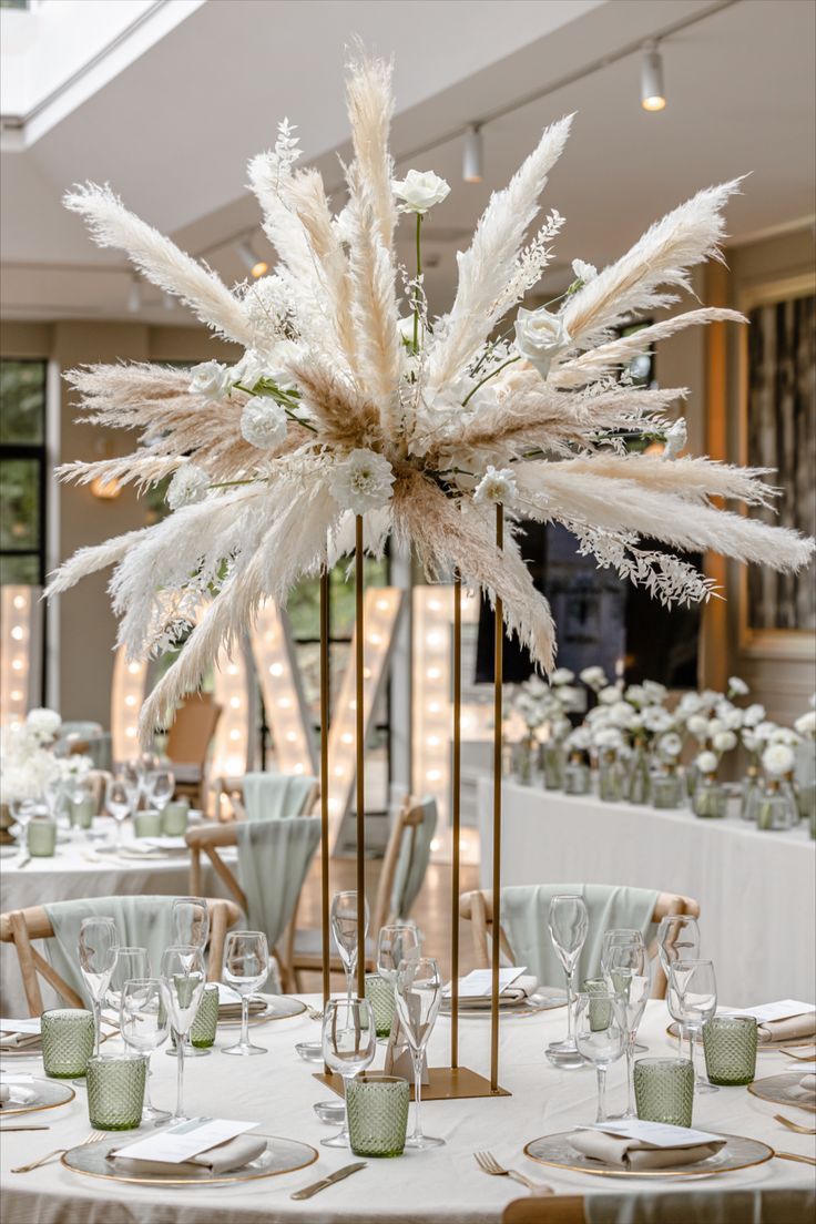 the centerpieces are decorated with white flowers and feathers