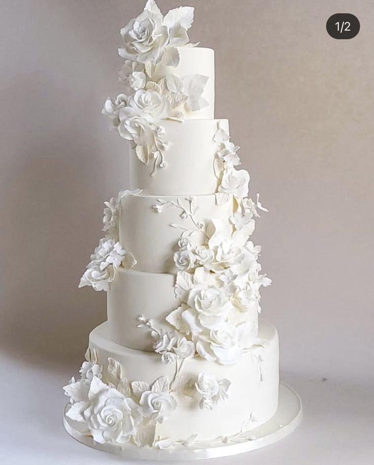 a three tiered white wedding cake with flowers