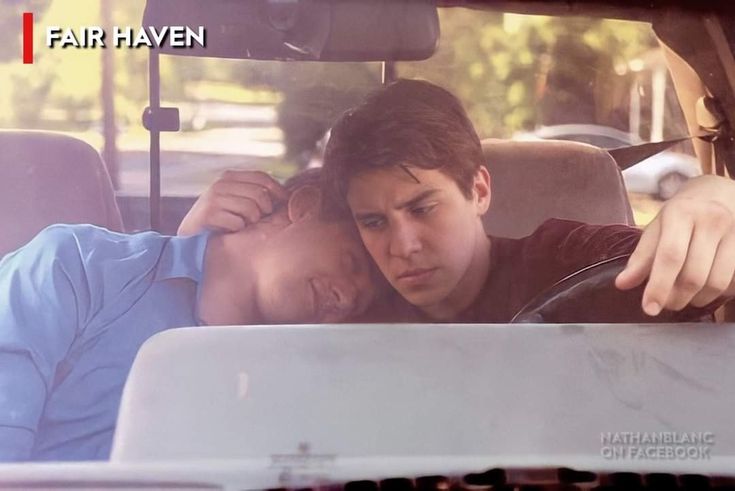 two people sitting in the back seat of a car