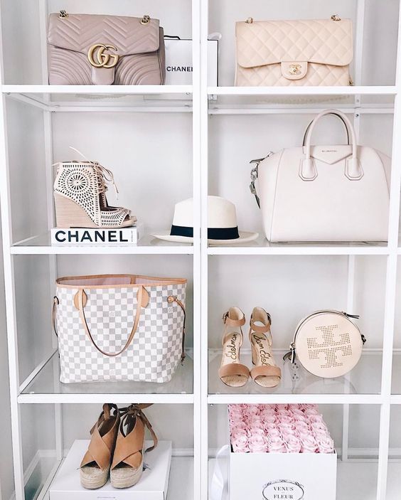 the shelves are filled with purses, handbags and other items in white shelving