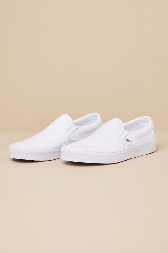 You'll reach for the Vans Classic True White Slip-On Sneakers time and time again when you want to create casually cool looks! These timeless sneakers have a sturdy canvas construction that creates a sleek silhouette with a rounded toe upper, elastic gussets at the sides, and a low-cut, padded collar. The effortless slip-on design makes these shoes essential when you have places to go and things to do! Logo tag at the outstep and heel. 1" rubber sole. Lightly cushioned insole. Rubber sole has no Slip-on Canvas Shoes With Vulcanized Sole For Streetwear, Casual White Slip-ons With Contrast Sole, Streetwear Slip-on Canvas Shoes With Gum Sole, White Vulcanized Sole Slip-ons For Streetwear, High-top Slip-ons With Vulcanized Sole For Streetwear, High-top Slip-ons For Streetwear, Casual Canvas Slip-ons For Streetwear, Casual White Slip-ons For Streetwear, Vans Classic Slip-on Sneakers With Vulcanized Sole