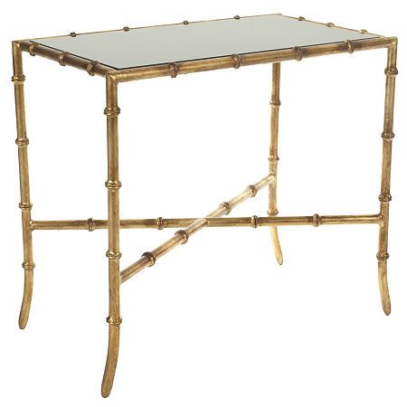 a glass table with gold bamboo legs and a clear top on an isolated white background