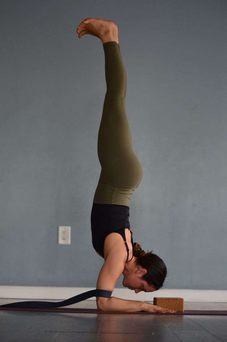 a woman is doing a handstand on the floor