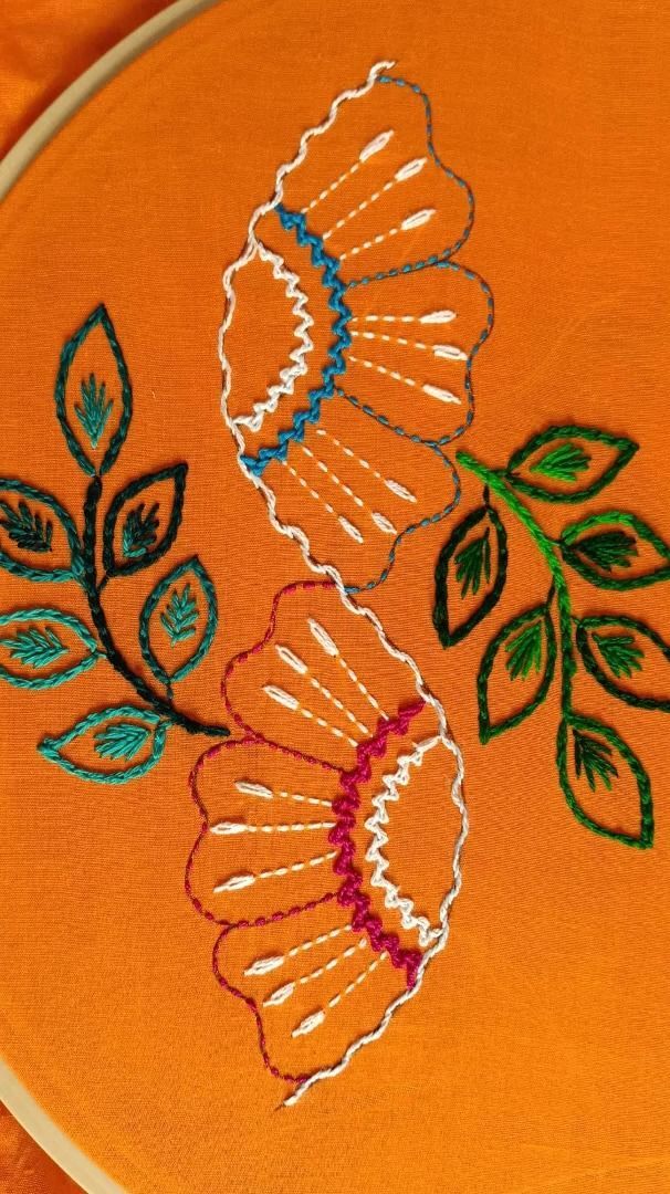 an orange embroidered cloth with flowers on it