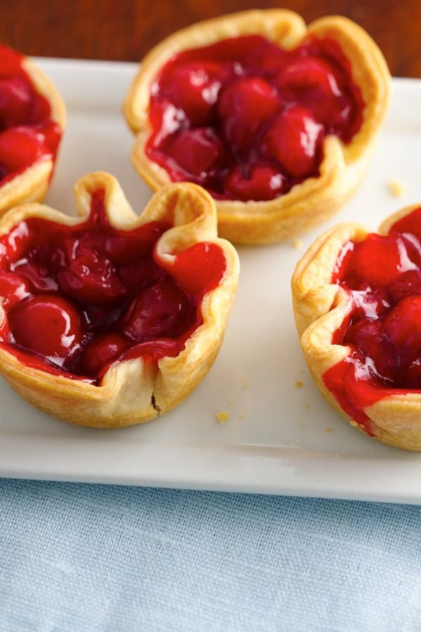 three mini tarts with jelly filling on a white plate