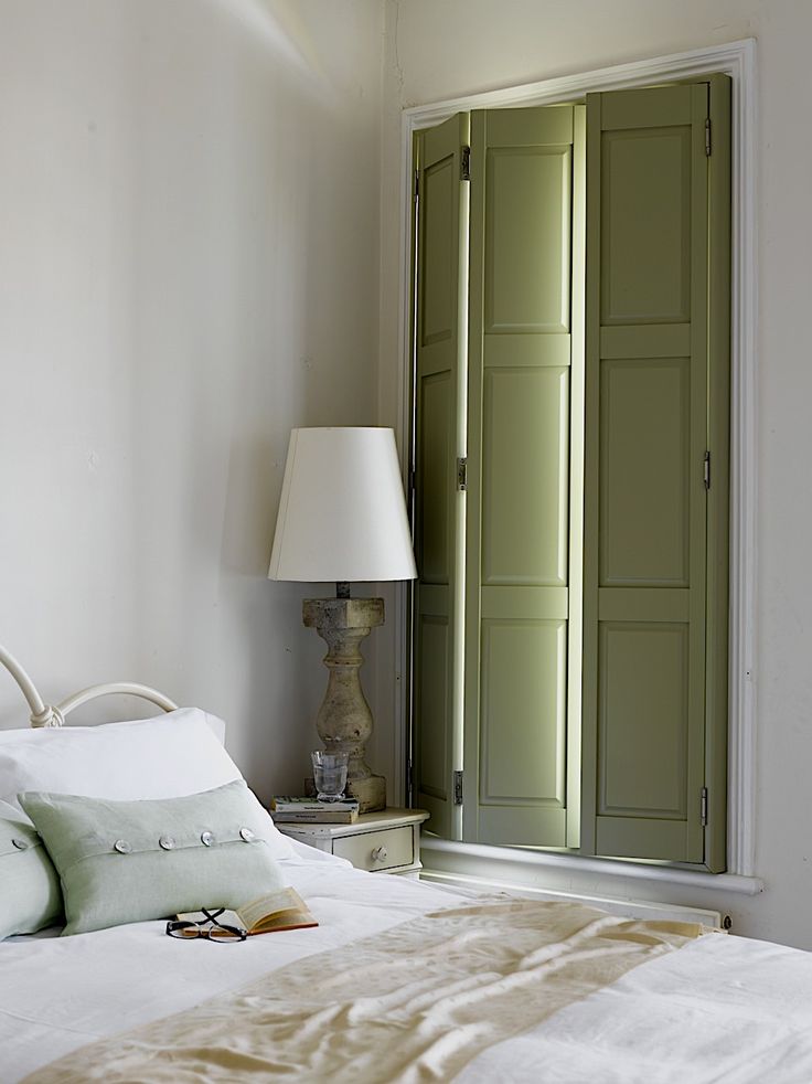 a white bed sitting next to a green door