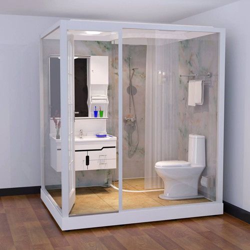 a white toilet sitting inside of a bathroom next to a walk in shower and sink