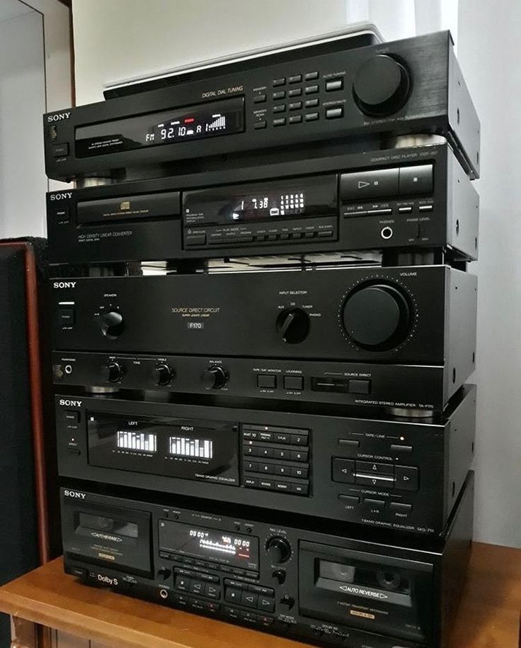 a stack of stereo equipment sitting on top of a wooden table