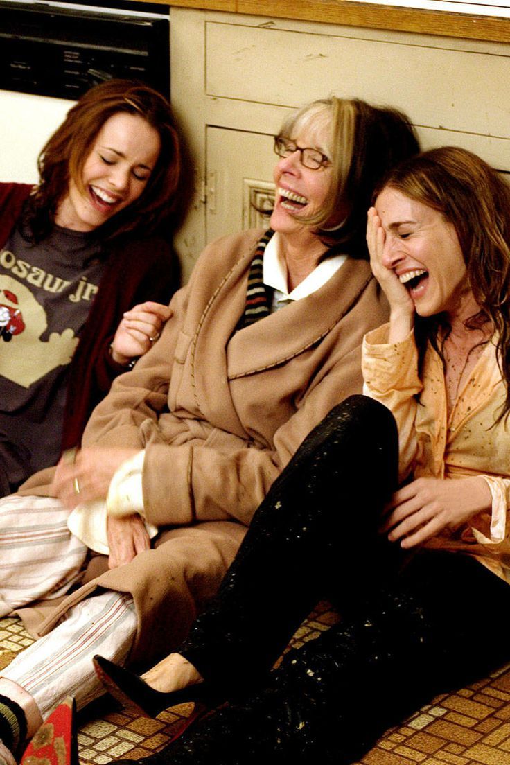 three women laughing while sitting on the floor