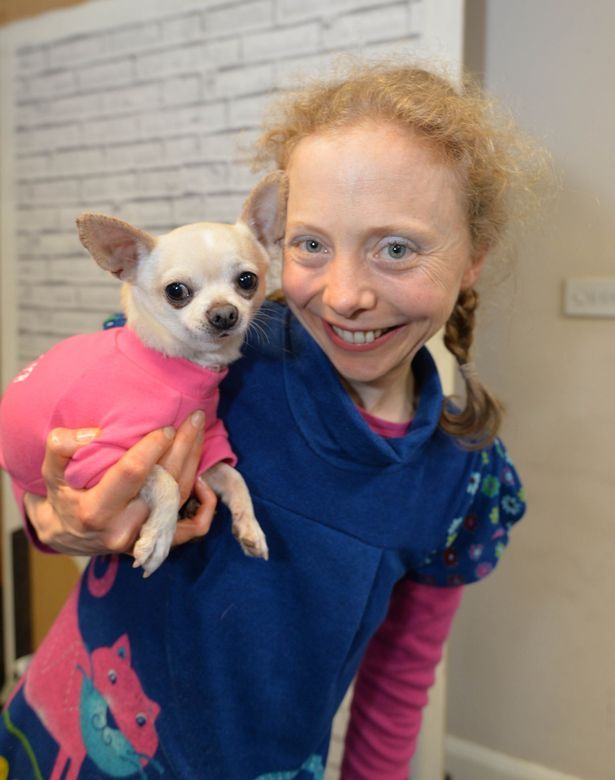 a woman holding a small dog in her arms