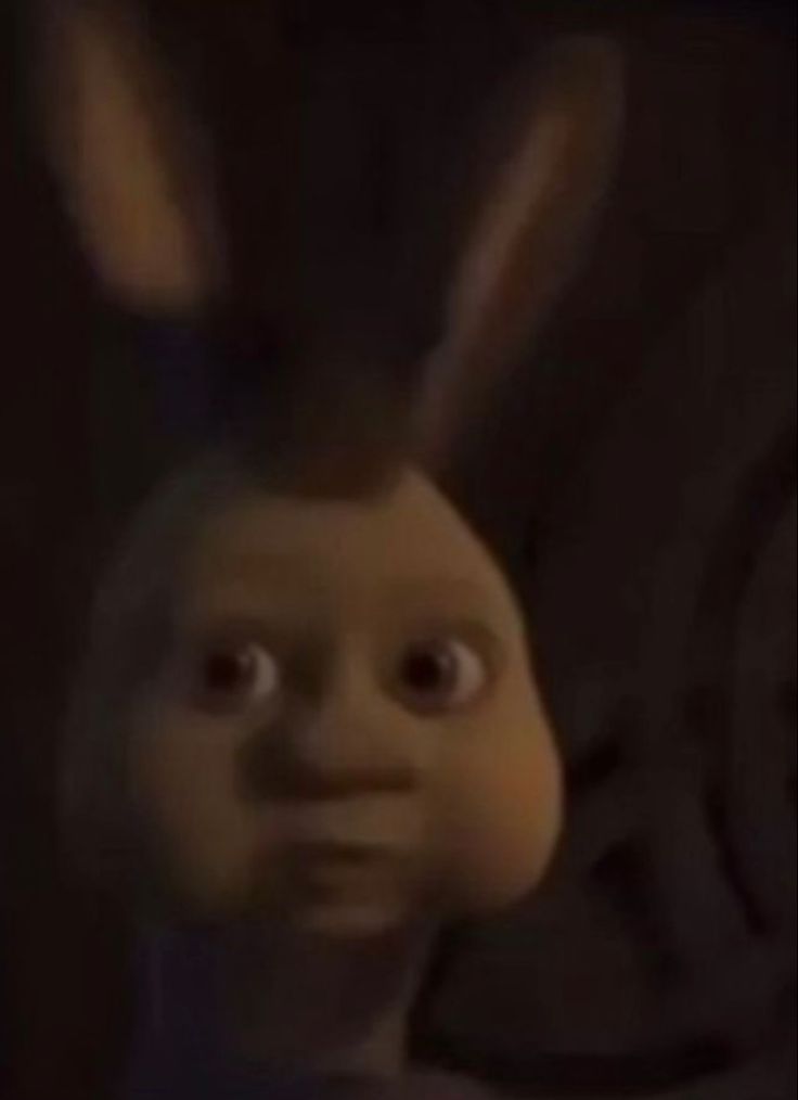 an animated character with big ears and eyes looking up at the camera while standing in front of a dark background