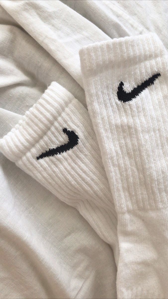 two white socks with black nike logo on them