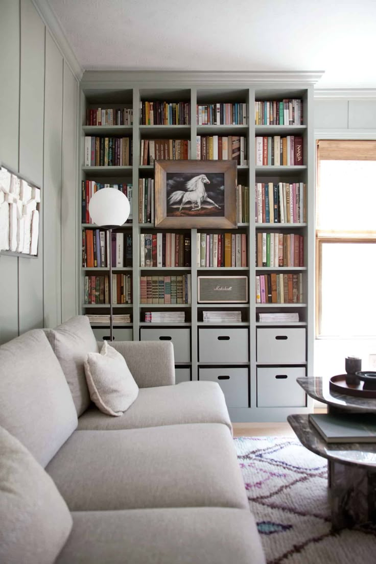 a living room filled with lots of furniture and bookshelves