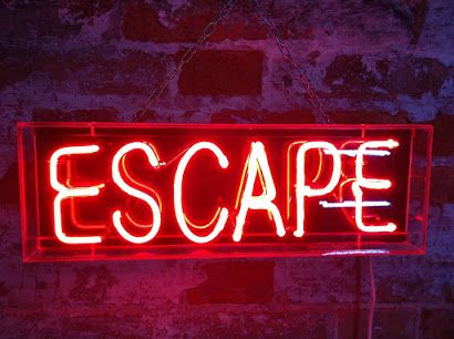 a neon sign that says escape hanging on a brick wall