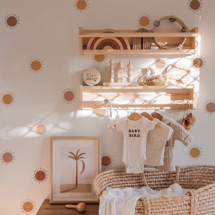 a baby's clothes hanging on a rack in a room with sunburst wallpaper