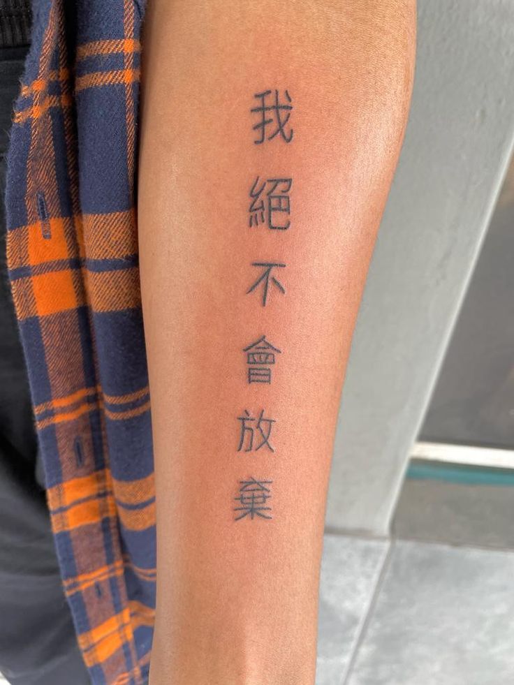 a person with a tattoo on their arm that has chinese characters written in different languages