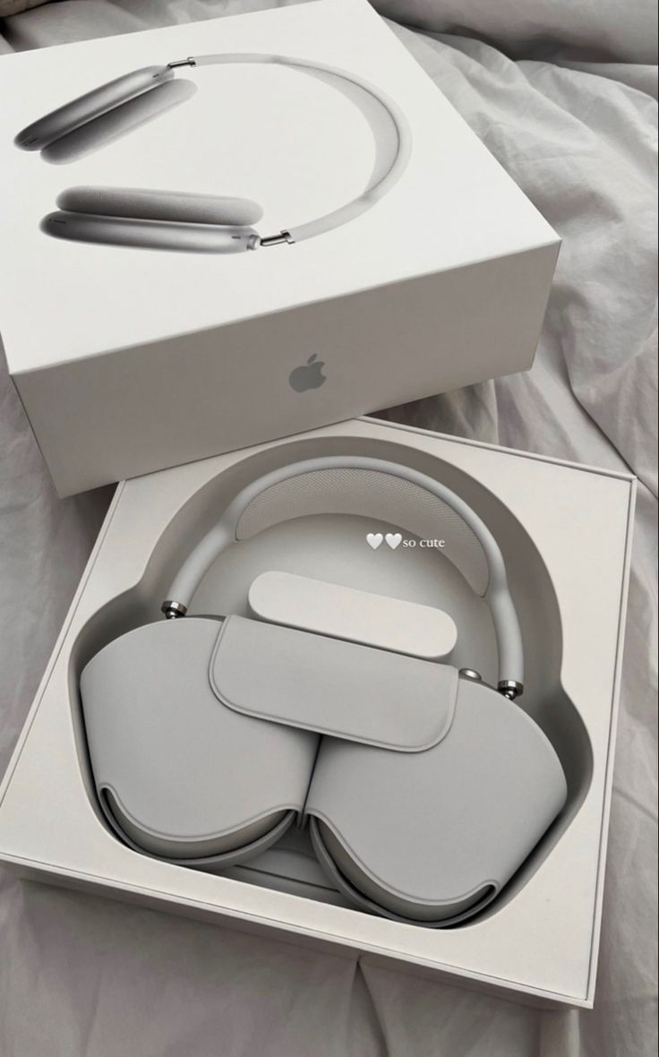 an apple product in its box with the lid open and headphones attached to it