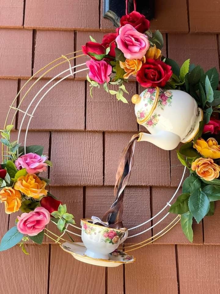 a tea pot is being poured into a cup with flowers on the outside of it