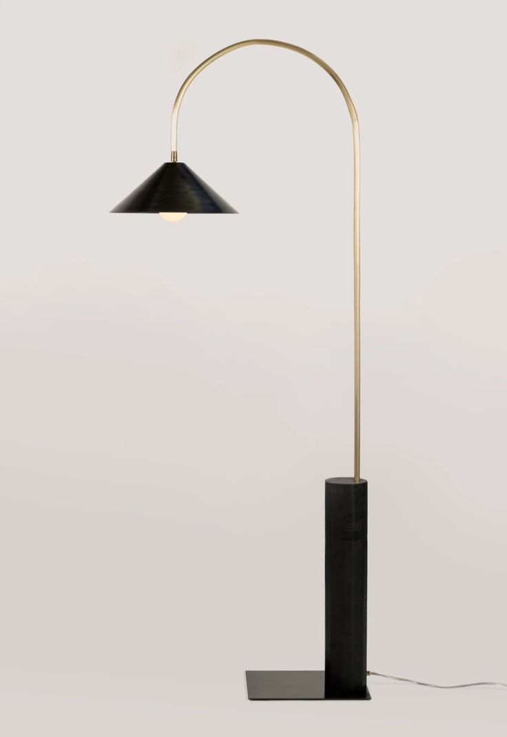 a black and gold floor lamp on a white background with a cord attached to it