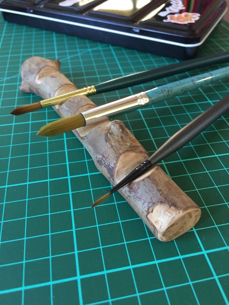 three different types of pens sitting on top of a green cutting board