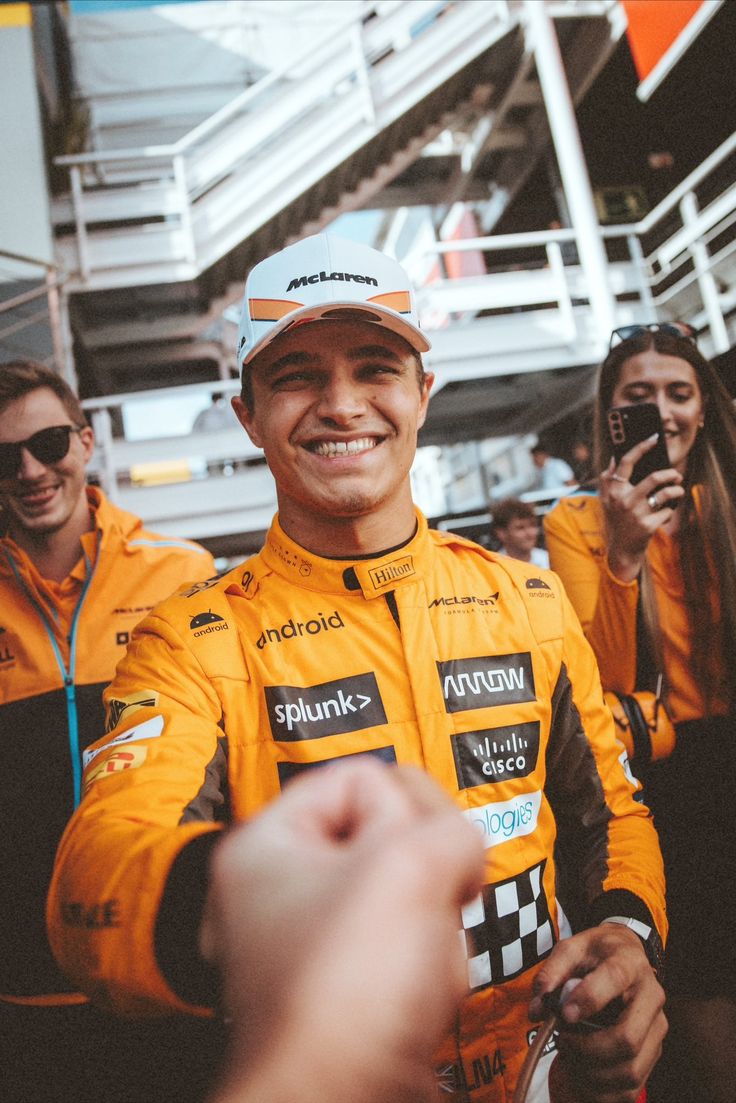 a man in a yellow racing suit is taking a selfie with his cell phone