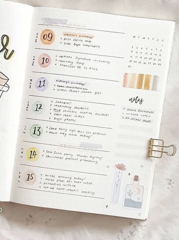 an open planner with numbers and things to do on it, next to a cup of coffee