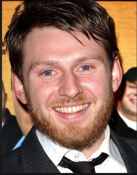 a close up of a person wearing a suit and tie