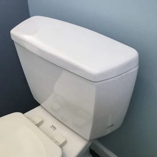 a white toilet sitting in a bathroom next to a blue wall