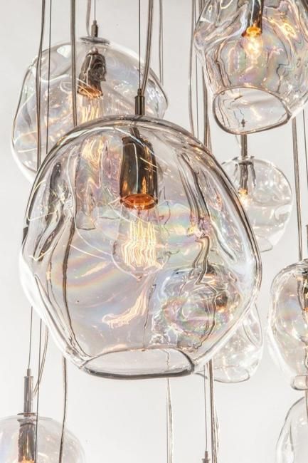 a chandelier with many glass balls hanging from it's sides and lights in the middle