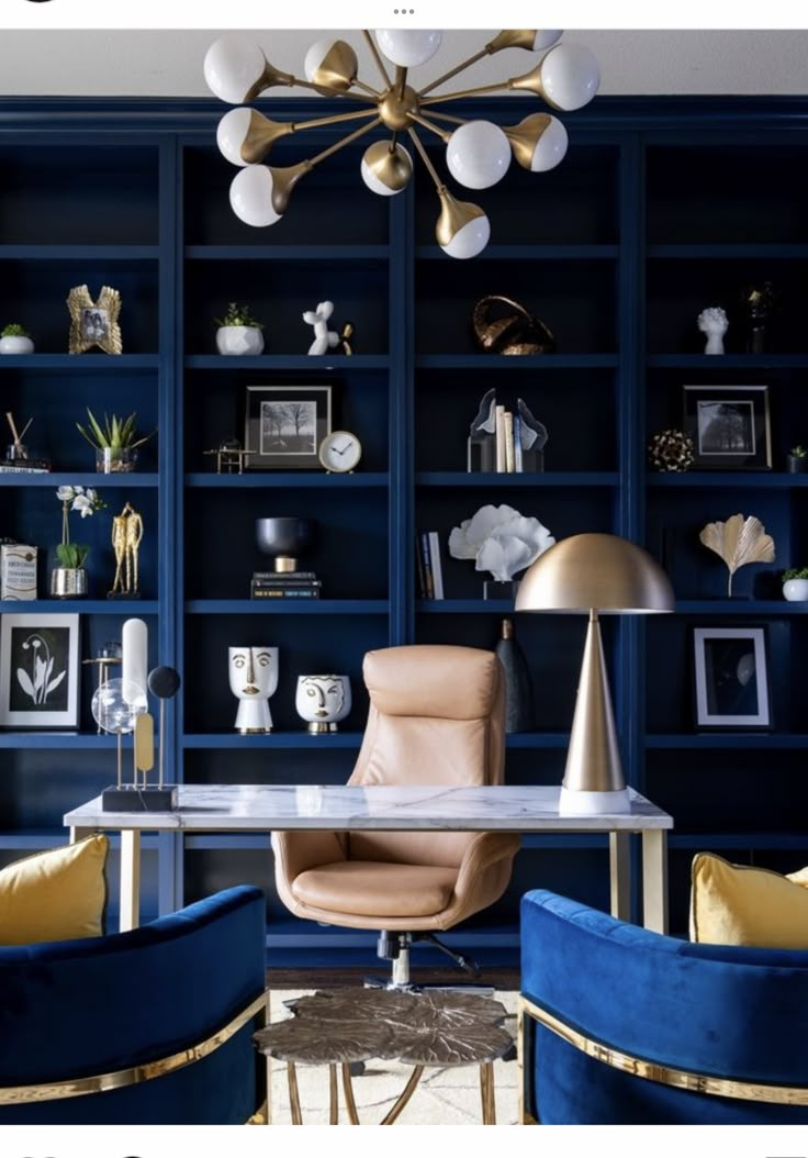 an office with blue bookcases and gold accents