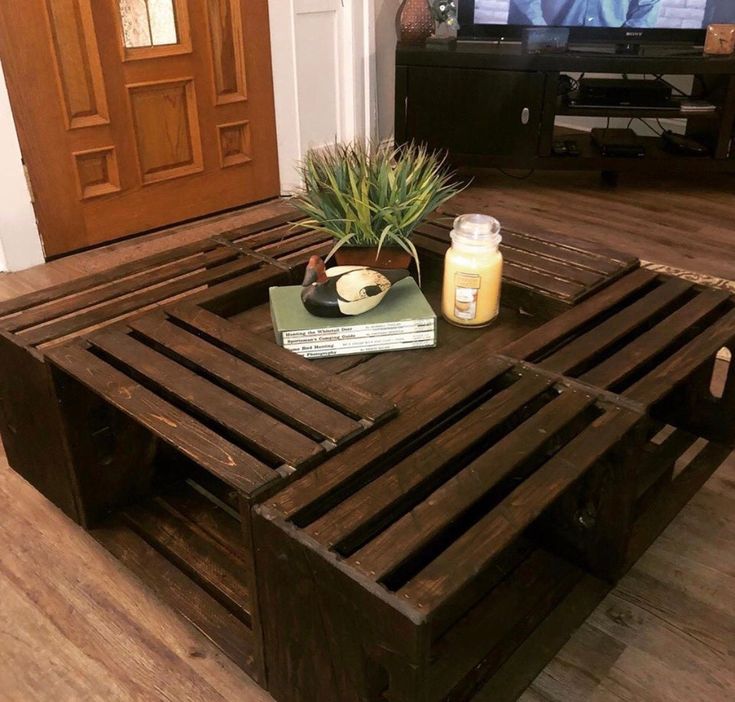 a coffee table made out of pallet wood with a plant on top and books