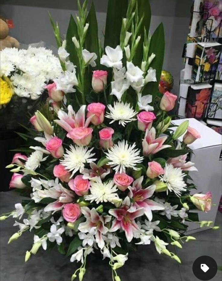 a vase filled with lots of white and pink flowers