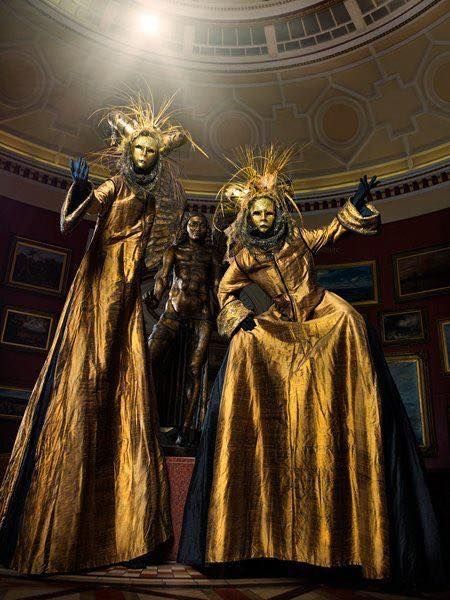 two statues are dressed in gold and black