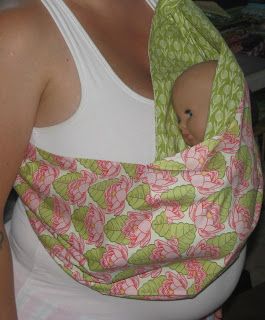 a woman wearing a baby sling wrapped around her head and breast in a white tank top