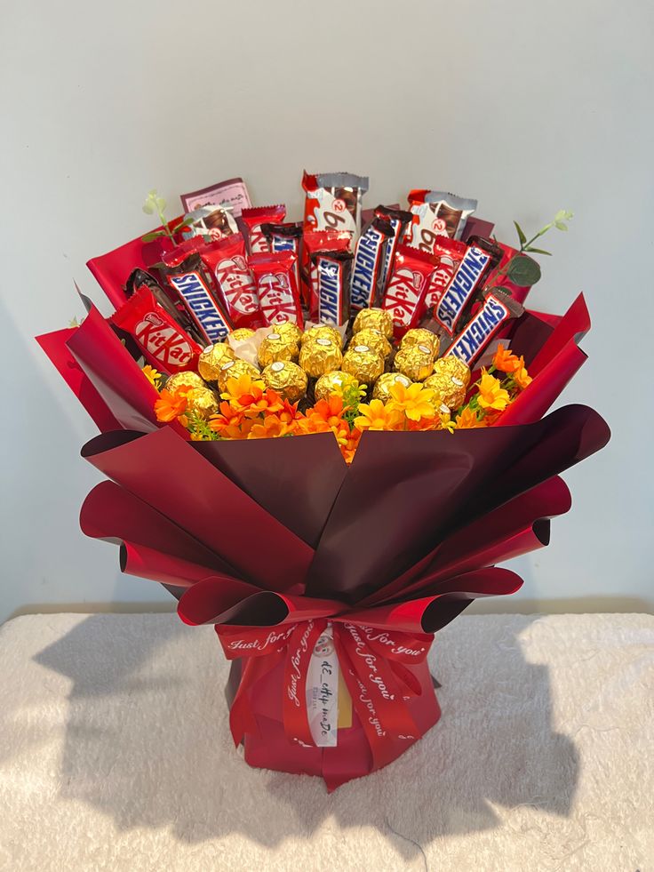 a bouquet of candy and candies in a red paper wrapper on a table