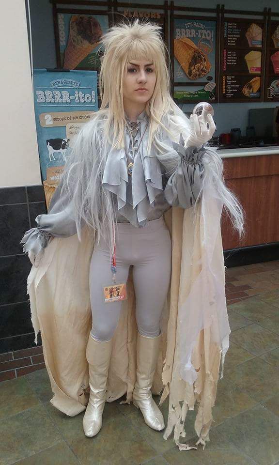 a woman dressed in costume standing next to a counter