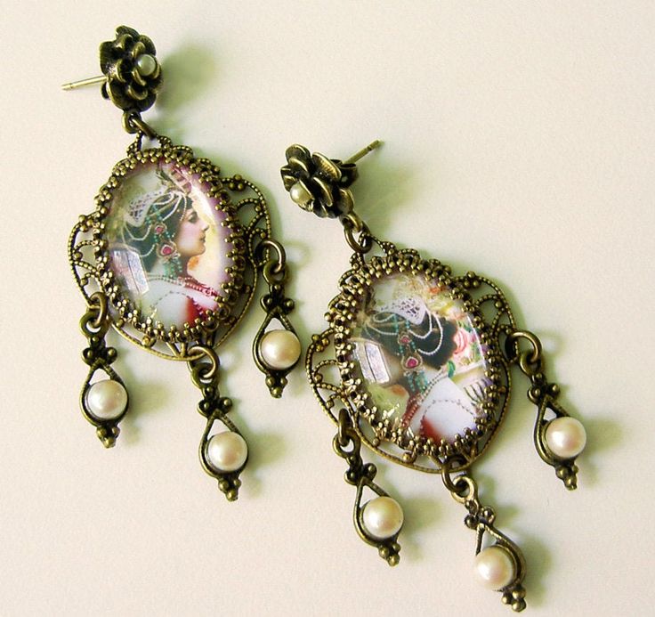 Mata Hari. Bet you didn't know she was a real person, eh? Oh, you did? Then you are super smart. I like super smart, don't you? These are lovely...easy to wear and ornate post earrings with pearl accents and fancy filigree setting evocative of the mysterious persona she worked so hard to convey. 1.75 inches long. If you like wearing fun art, You might want to check out my sister shop: DemetersSpring.etsy.com (Please note any earring clasp pictured in the listing can be converted to one of your p Ornate Bronze Earrings For Gift, Antique Gold Earrings As Gift, Artistic Bronze Jewelry For Gifts, Bronze Vintage Earrings With Oxidized Finish, Vintage Bronze Earrings With Oxidized Finish, Artistic Bronze Jewelry For Gift, Bronze Antique Finish Drop Earrings, Artistic Bronze Jewelry Gift, Antique Finish Copper Earrings As Gift