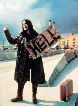 a woman is holding up a sign that says hello in front of her and luggage behind her