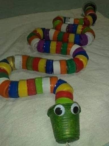 colorful snake made out of plastic cups on top of a white sheet with eyes and mouth