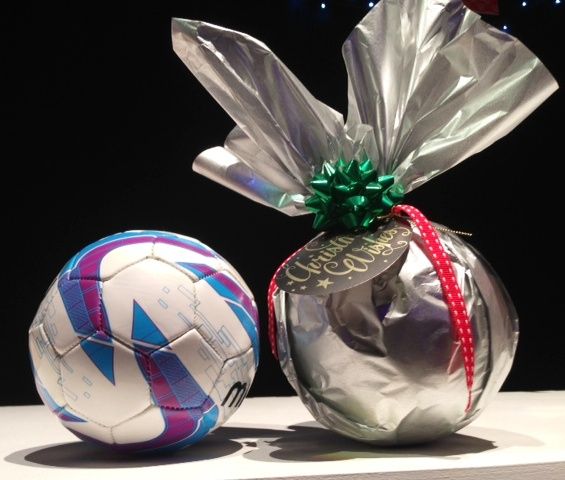 two soccer balls sitting next to each other on a table