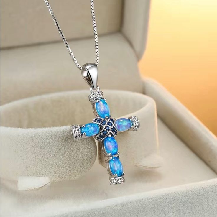 Beautiful Synthetic Blue Opal Cross With Sapphire Color Accent Stones Silver Cross Jewelry With Birthstone, Blue Clavicle Chain Jewelry As Gift, Blue Clavicle Chain Jewelry For Gifts, Blue Clavicle Chain Jewelry Gift, Blue Spiritual Cross Jewelry, Blue Cross Spiritual Jewelry, Silver Cross Pendant Necklace With Birthstone, Blue Cross Spiritual Necklace, Spiritual Blue Cross Pendant Necklace