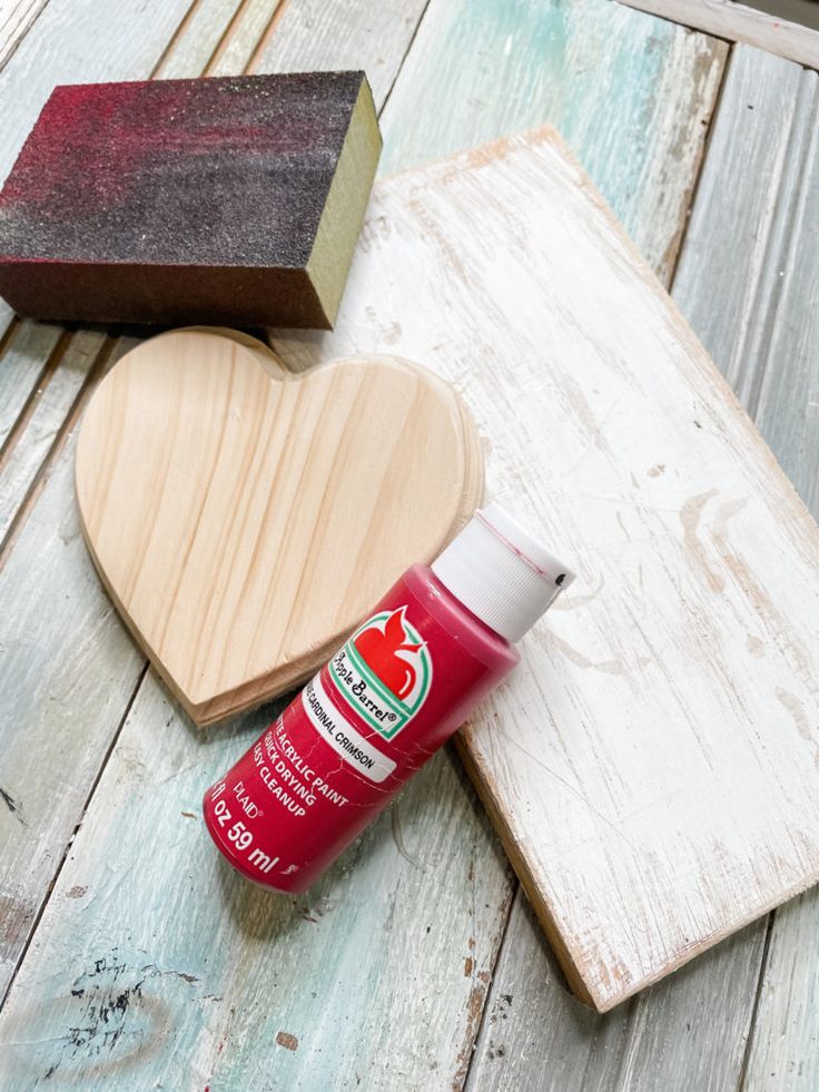 a heart shaped wooden box next to some glue