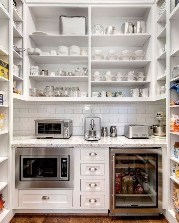 a kitchen with white cabinets and open shelving