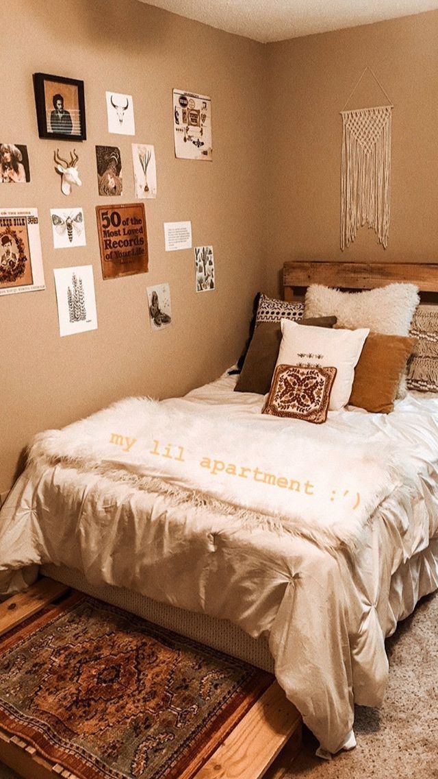 a bed sitting in a bedroom next to a wall with pictures on it