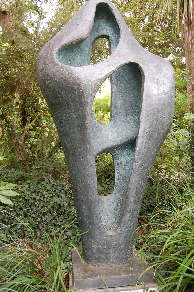 a sculpture sitting in the middle of a lush green forest