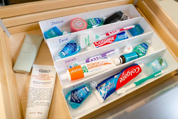 an open drawer with toothbrushes and lotion in it