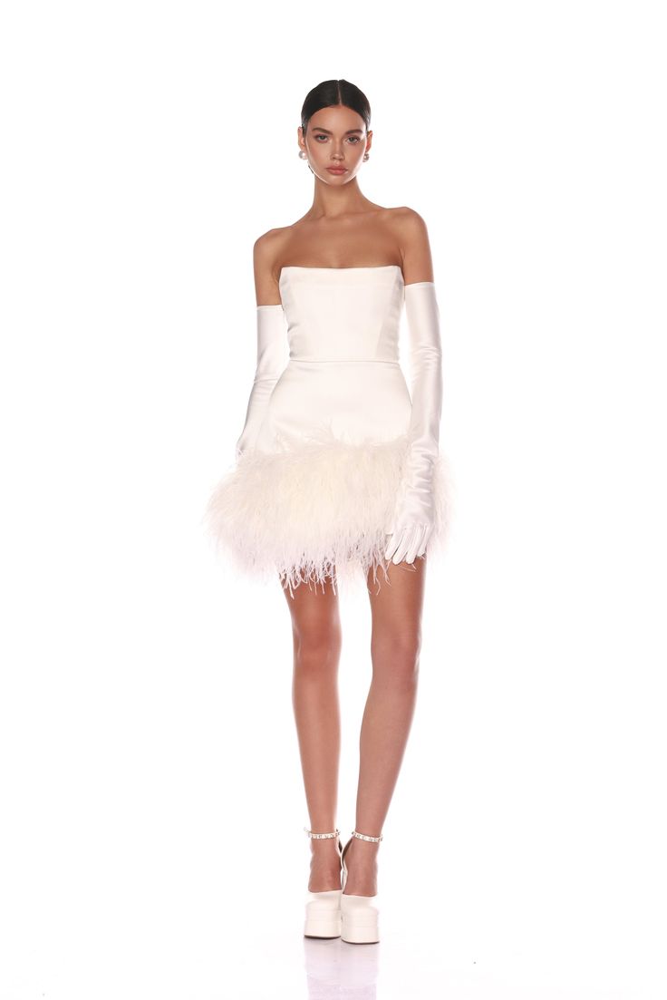 Elevate your elegance with the Fiora White Bridal Mini Dress from our La Danse Blanche collection. Strapless, square neckline Boned bodice Feather-trimmed hem Corset and back zipper closure Gloves not included White Feather Mini Dress, Sleeveless Wedding Dress With Gloves, Winter Wedding Reception Dress, Rehearsal Dinner Bride Dress, Reception Dress Feathers, After Party Bridal Dress, Feather White Dress, White Rhinestone Dress, Vintage Short Wedding Dress