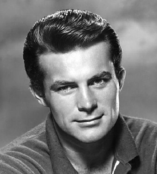 an old black and white photo of a man with short hair wearing a polo shirt