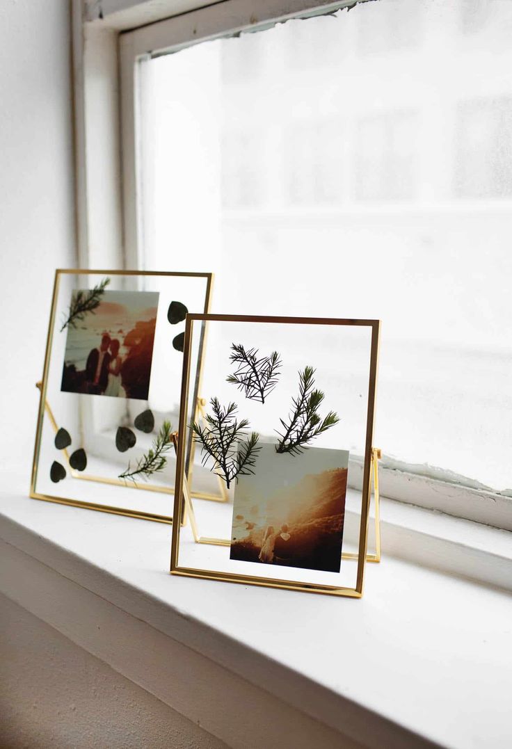 two frames are sitting on a window sill