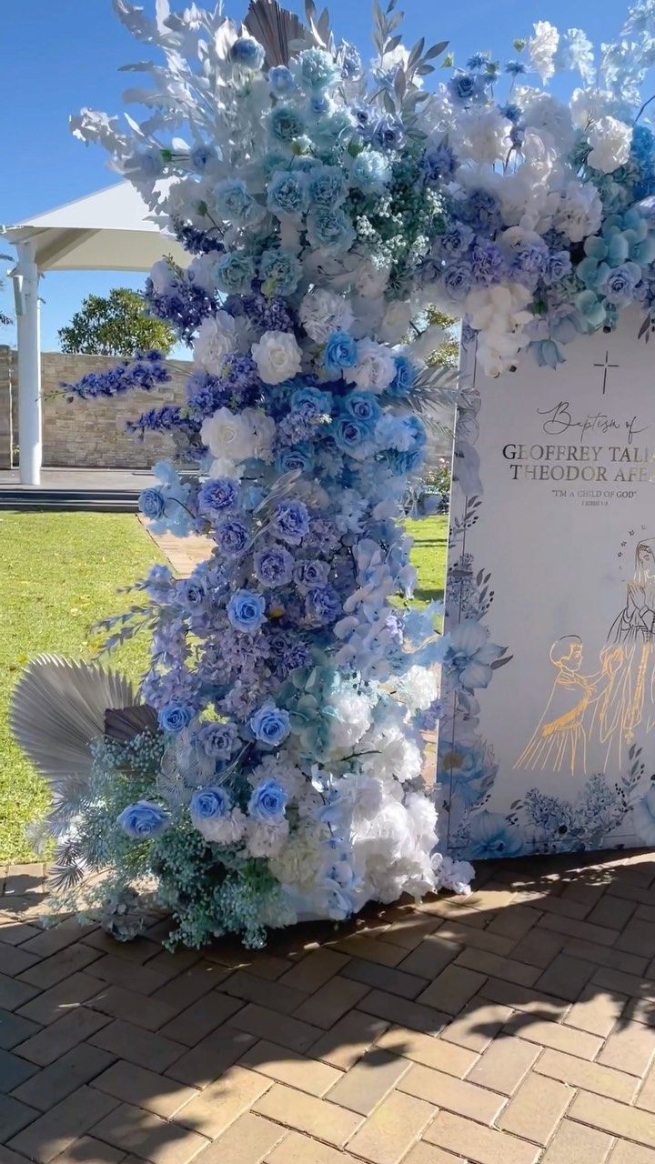 a blue and white wedding arch with flowers